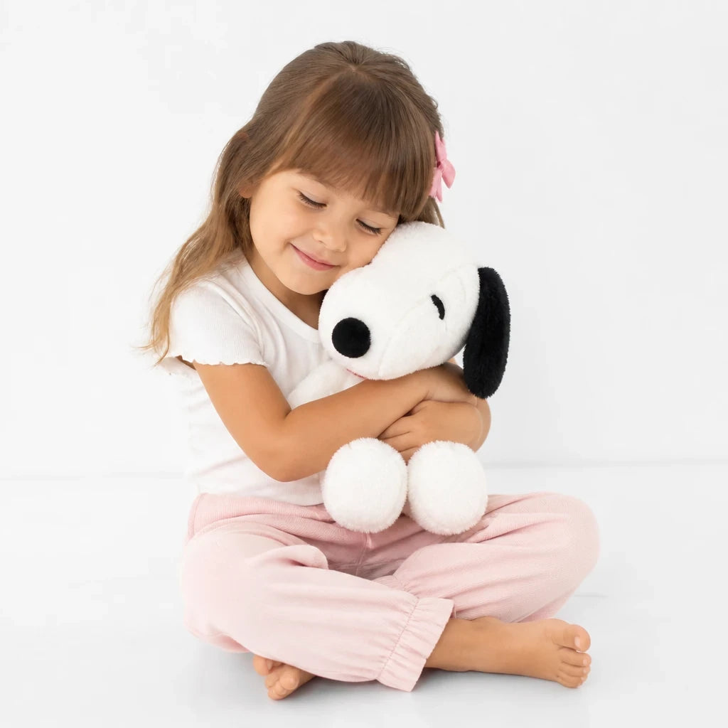 Menina abraça pelúcia travesseiro Snoopy macio, aconchegante e seguro, ideal para cabana infantil e cantinho de descanso