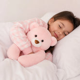 Menina dormindo abraçada em pelúcia infantil rosa ponderada de braço longo e toque macio para sono aconchegante