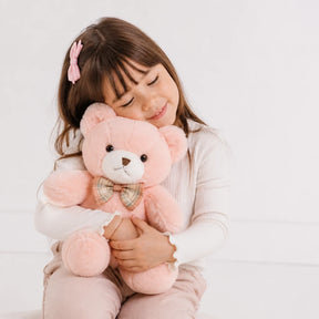 Menina abraçando ursinho de pelúcia rosa macio 30cm, companheiro de sono confortável e seguro para crianças
